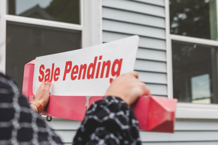 Realtor Realtor pasting a sign on a house for sale